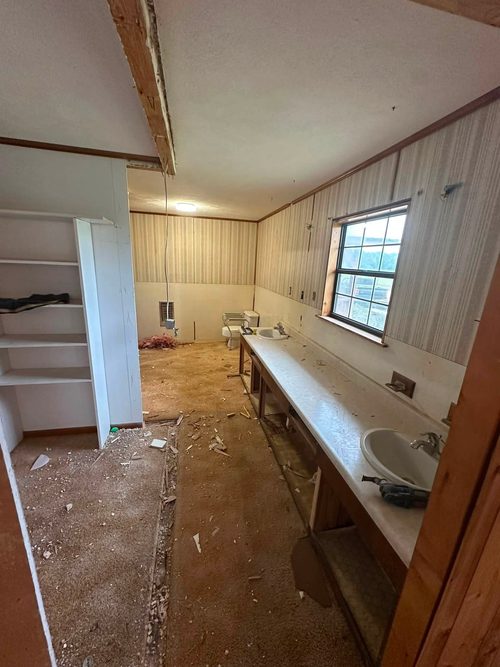 Master bathroom stripped back to bare walls with the old vanity removed.