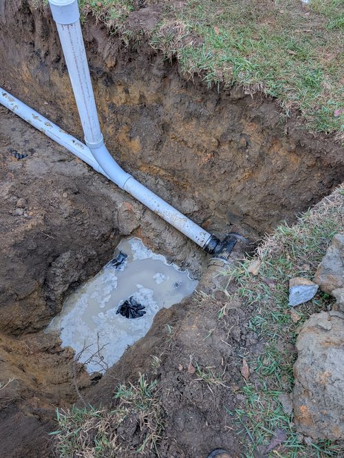 A newly laid sewer line running through an open trench.